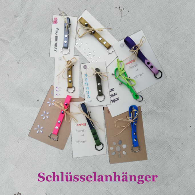 Schlüsselbänder in unterschiedlichen Farben & Längen, mit und ohne Nieten auf Geschenkkarten.